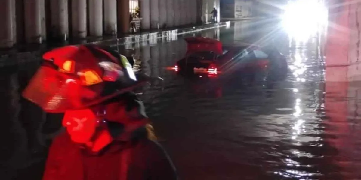 Bomberos rescatan a pasajeros atrapados por inundación en puente de Texmelucan