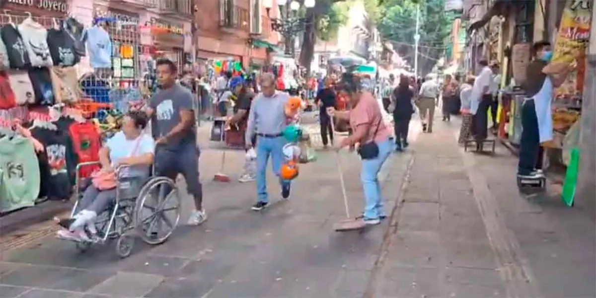 Comerciantes limpian calles del Centro Histórico de Puebla para prevenir nuevas inundaciones