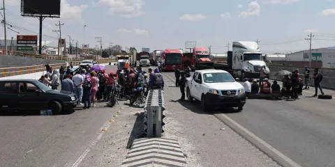 Transportistas bloquean autopista Puebla-Orizaba y Periférico Ecológico; exigen regreso de camiones de la Ruta 100